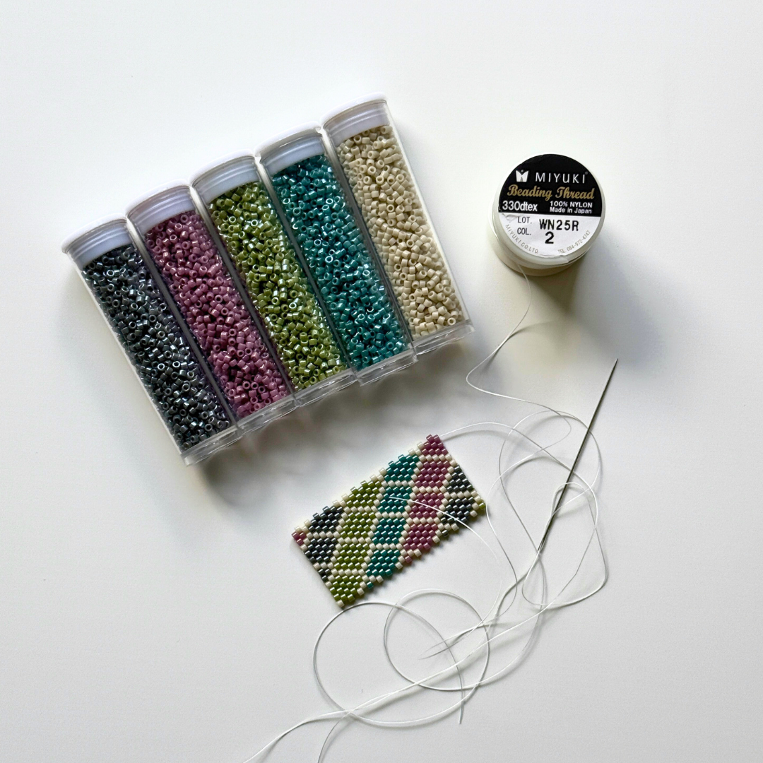 Close up of five tubes of beads and a swatch of peyote beading
