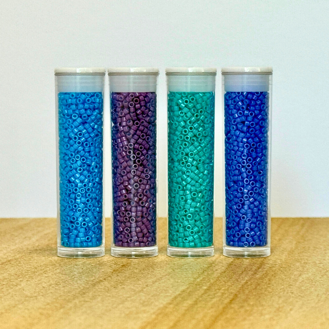 Close up of four tubes of beads.
