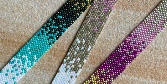 A bracelet in purples and pinks on a wooden surface.