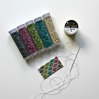 Close up of five tubes of beads and a swatch of peyote beading